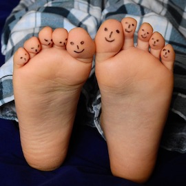 Decorative image of a child's toes with faces drawn on
