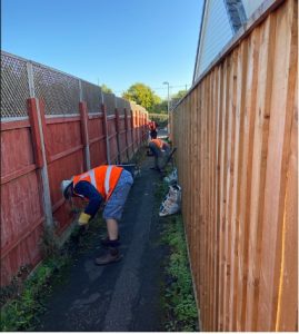 Photo showing de-weeding of the alley between Paddock Close and Purbeck Close